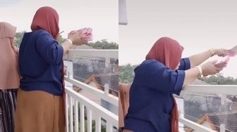 Lempar Uang Rp 100 Juta dari Atas Rumah, Aksi Wanita Ini Buat Heboh