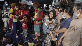 Anggota komunitas Aku Badut Indonesia (ABI) menghibur anak-anak korban kebakaran di Keagungan, Taman Sari, Jakarta, Kamis (22/4/2021). [Suara.com/Angga Budhiyanto]