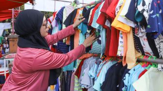 Warga memilih baju yang dijual di stand bazar ramadhan Taman Mini Indonesia Indah, Jakarta Timur, Sabtu (24/4/2021). [Suara.com/Alfian Winanto]