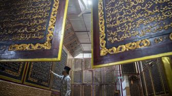 Pengunjung membaca ayat-ayat yang ada di Al Quran Al-Akbar di Palembang, Sumatera Selatan, Jumat (23/4/2021).  ANTARA FOTO/Nova Wahyudi