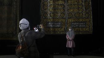 Pengunjung berfoto di depan salah satu koleksi dalam Pameran Artefak Nabi Muhammad SAW di Jakarta Islamic Center, Koja, Jakarta, Minggu (25/4/2021). [Suara.com/Dian Latifah]