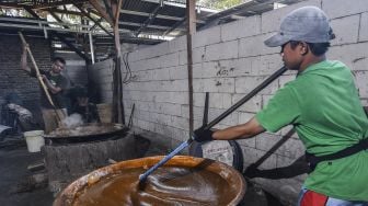 Sejumlah pekerja mengaduk dodol dalam kuali di rumah produksi Empat Saudara, Desa Sukajaya, Cibitung, Kabupaten Bekasi, Jawa Barat, Minggu (25/4/2021). [ANTARA FOTO/Fakhri Hermansyah]