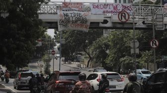 Spanduk Persija Jakarta juara Piala Menpora 2021 terpasang di salah satu jembatan penyeberangan orang (JPO) kawasan Mampang Prapatan, Jakarta, Senin (26/4/2021). [Suara.com/Angga Budhiyanto]