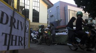 Panitia penyelenggara membagikan takjil secara Drive Thru di GPIB Bukit Moria, Jalan Prof.Dr.Soepomo, Kecamatan Tebet, Jakarta Selatan, Senin (26/4/2021). [Suara.com/Dian Latifah]