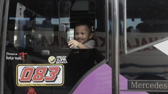 Seorang anak berada di dalam bus di Terminal Pulo Gebang, Jakarta Timur, Selasa bus di Terminal Pulo Gebang, Jakarta Timur, Selasa (27/4/2021). [Suara.com/Angga Budhiyanto]