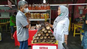 Warga membeli lemang untuk berbuka puasa di Food Street Kramat di Kawasan Senen, Jakarta Pusat, Selasa (27/4/2021). [Suara.com/Alfian Winanto]