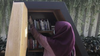 Warga memilih koleksi buku di perpustakaan bersama Bookhive Jakarta di kawasan Taman Situ Lembang, Jakarta, Selasa (27/4/2021). [Suara.com/Angga Budhiyanto]