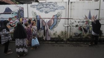 Warga memilah sayuran dan pakaian bekas layak pakai yang dijajakan secara gratis di Jalan Jati Padang VI RT 002 RW 004, Pasar Minggu, Jakarta Selatan, Rabu (28/4/2021). [Suara.com/Angga Budhiyanto]