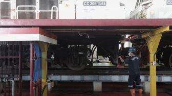 Pekerja beraktivitas melakukan perawatan rutin pada lokomotif di Depo Kereta Cipinang, Jakarta, Kamis (29/4/2021). [Suara.com/Angga Budhiyanto]