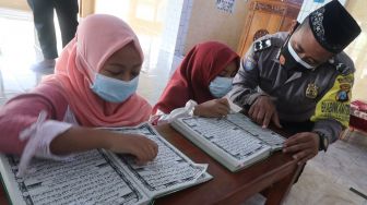 Polisi Mengajar Anak-anak Membaca Al Quran