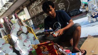 Penjual membuat parsel di kiosnya di Jalan Pegangsaan Timur, Cikini, Jakarta Pusat, Jumat (30/4/2021).  [Suara.com/Dian Latifah]
