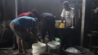 Pekerja menyiapkan adonan dodol Betawi di Pondok Dodol Sari Rasa Ibu Yuyun di kawasan Pasar Minggu, Jakarta Selatan, Jumat (30/4/2021). [Suara.com/Angga Budhiyanto]