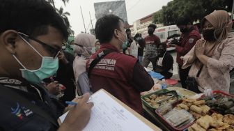 Petugas Puskesmas Gambir melakukan pendataan makanan dari pedagang takjil untuk uji laboratorium di kawasan Petojo Utara, Gambir, Jakarta Pusat, Jumat (30/4/2021). [Suara.com/Angga Budhiyanto]