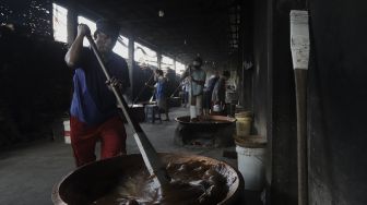 Pekerja mengaduk adonan dodol Betawi di Pondok Dodol Sari Rasa Ibu Yuyun di kawasan Pasar Minggu, Jakarta Selatan, Jumat (30/4/2021). [Suara.com/Angga Budhiyanto]