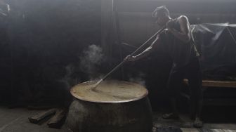 Pekerja mengaduk adonan dodol Betawi di Pondok Dodol Sari Rasa Ibu Yuyun di kawasan Pasar Minggu, Jakarta Selatan, Jumat (30/4/2021). [Suara.com/Angga Budhiyanto]