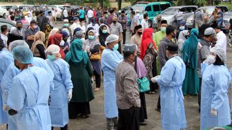 Sejumlah pelayat dan tenaga medis menunggu kedatangan jenazah almarhum Wakil Wali Kota Dumai Amris di Taman Makam Pahlawan Dumai, Riau, Kamis (29/4/2021). ANTARA FOTO/Aswaddy Hamid