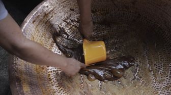 Pekerja menyelesaikan proses pembuatan dodol Betawi di Pondok Dodol Sari Rasa Ibu Yuyun di kawasan Pasar Minggu, Jakarta Selatan, Jumat (30/4/2021). [Suara.com/Angga Budhiyanto]