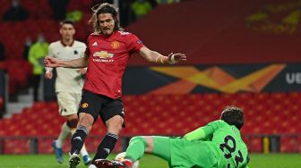 Striker Manchester United Edinson Cavani menembak melewati penjaga gawang Roma Antonio Mirante untuk mencetak gol ketiga selama pertandingan sepak bola leg pertama semifinal Liga Europa antara Manchester United melawan Roma di Old Trafford, Jumat (30/4/2021) dini hari WIB.
Paul ELLIS / AFP
