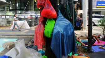 Sejumlah pencari suaka beraktivitas di trotoar depan kantor UNHCR, Jalan Kebon Sirih, Jakarta, Jumat (30/4/2021).  [Suara.com/Dian Latifah]