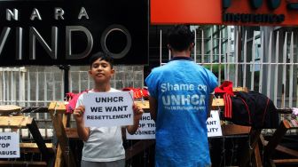 Sejumlah pencari suaka beraktivitas di trotoar depan kantor UNHCR, Jalan Kebon Sirih, Jakarta, Jumat (30/4/2021).  [Suara.com/Dian Latifah]