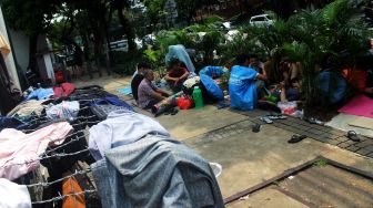 Sejumlah pencari suaka beraktivitas di trotoar depan kantor UNHCR, Jalan Kebon Sirih, Jakarta, Jumat (30/4/2021).  [Suara.com/Dian Latifah]