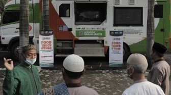 Warga menunggu pembagian makanan untuk berbuka puasa yang disalurkan oleh Suara.com dan ACT di di Masjid Husnul Khatimah, Jatiasih, Kota Bekasi, Minggu (2/5/2021). [Suara.com/Angga Budhiyanto]