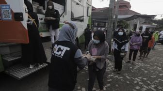 Relawan membagikan makanan kepada warga untuk berbuka puasa di Masjid Husnul Khatimah, Jatiasih, Kota Bekasi, Minggu (2/5/2021). [Suara.com/Angga Budhiyanto]