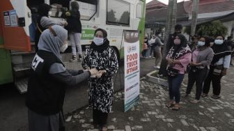 Relawan membagikan makanan kepada warga untuk berbuka puasa di Masjid Husnul Khatimah, Jatiasih, Kota Bekasi, Minggu (2/5/2021). [Suara.com/Angga Budhiyanto]