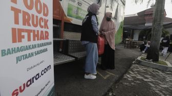 Relawan membagikan makanan kepada warga untuk berbuka puasa di Masjid Husnul Khatimah, Jatiasih, Kota Bekasi, Minggu (2/5/2021). [Suara.com/Angga Budhiyanto]