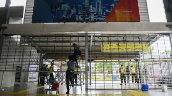 Petugas kebersihan menutup pagar Stasiun Tanah Abang, di Jakarta, Senin (3/5/2021). ANTARA FOTO/Galih Pradipta