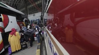 Sejumlah calon penumpang memasukkan barang bawaanya ke dalam bagasi bus di Terminal Pulo Gebang, Jakarta Timur, Selasa (4/5/2021). [Suara.com/Angga Budhiyanto]