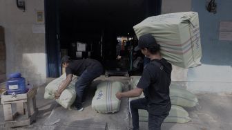 Pekerja mengangkut barang yang akan dikirim via jasa ekspedisi kereta api di Jalan Bungur Raya, Senen, Jakarta, Selasa (4/5/2021). [Suara.com/Angga Budhiyanto]