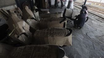 Pekerja mengemas sepeda motor sebelum dikirim via jasa ekspedisi kereta api di Jalan Bungur Raya, Senen, Jakarta, Selasa (4/5/2021). [Suara.com/Angga Budhiyanto]