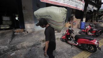 Pekerja mengangkut barang yang akan dikirim via jasa ekspedisi kereta api di Jalan Bungur Raya, Senen, Jakarta, Selasa (4/5/2021). [Suara.com/Angga Budhiyanto]