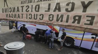 Sejumlah calon penumpang memasukkan barang bawaannya ke dalam bagasi bus di Terminal Lebak Bulus, Jakarta, Rabu (5/5/2021). [Suara.com/Angga Budhiyanto]