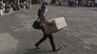 Calon penumpang membawa barang bawaannya berjalan menuju bus di Terminal Lebak Bulus, Jakarta, Rabu (5/5/2021). [Suara.com/Angga Budhiyanto]