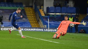 Striker Chelsea Timo Werner (kiri) mencetak gol melewati kiper Real Madrid Thibaut Courtois, tetapi gol itu dianulir karena offside, selama pertandingan sepak bola semifinal leg kedua Liga Champions antara Chelsea melawan Real Madrid di Stamford Bridge,  Kamis (6/5/2021) dini hari 
Glyn KIRK / AFP
