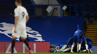 Penyerang Real Madrid Karim Benzema (kiri) bereaksi ketika gelandang Chelsea, Mason Mount dikerumuni rekan satu timnya setelah mencetak gol kedua selama pertandingan sepak bola semifinal leg kedua Liga Champions antara Chelsea melawan Real Madrid di Stamford Bridge,  Kamis (6/5/2021) dini hari WIB.Glyn KIRK / AFP