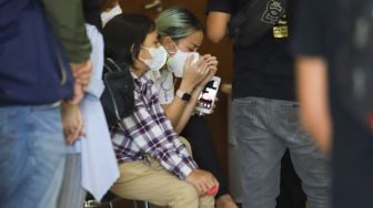 Aktris Joanna Alexandra ditemani anaknya Zeraiah Moria berdoa didepan peti jenazah suaminya, Raditya Oloan saat ibadah penghiburan di rumah duka RSPAD Gatot Subroto, Jakarta Pusat, Jumat (7/5/2021). [Suara.com/Alfian Winanto]