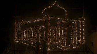 Warga menyalakan lentera yang digantung pada 'Lampu Colok' berbentuk miniatur masjid dalam Festival Lampu Colok di Pekanbaru, Riau, Sabtu (8/5/2021). [ANTARA FOTO/Rony Muharrman]