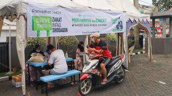 Warga membayar zakat secara drive thru di Masjid Nurul Hidayah, Tanah Kusir, Jakarta Selatan, Sabtu (8/5/2021). [Suara.com/Alfian Winanto]