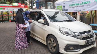 Warga membayar zakat secara drive thru di Masjid Nurul Hidayah, Tanah Kusir, Jakarta Selatan, Sabtu (8/5/2021). [Suara.com/Alfian Winanto]