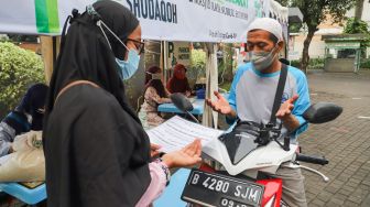 Warga berdoa usai membayar zakat secara drive thru di Masjid Nurul Hidayah, Tanah Kusir, Jakarta Selatan, Sabtu (8/5/2021). [Suara.com/Alfian Winanto]