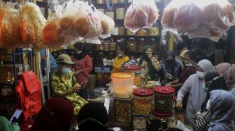 Suasana jual beli kue kering di salah satu toko di Pasar Mester Jatinegara, Jakarta, Minggu (9/5/2021). [Suara.com/Dian Latifah]