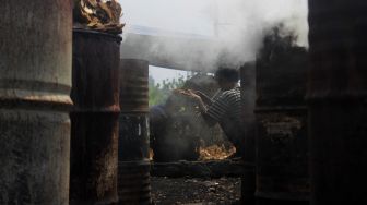 Pekerja memasukkan batok kelapa kering ke dalam keranjang di Kawasan Gang Sentiong, Kramat, Jakarta Pusat, Senin (10/5/2021). [Suara.com/Dian Latifah]