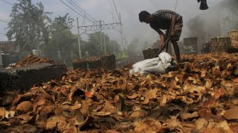 Pekerja menjemur batok kelapa di kawasan Gang Sentiong, Kramat, Jakarta Pusat, Senin (10/5/2021). [Suara.com/Dian Latifah]