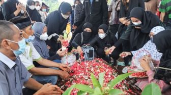 Keluarga berdoa diatas pusara komedian Sapri Pantun di TPU Ulujami, Pesanggrahan, Jakarta Selatan, Selasa (11/5/2021). [Suara.com/Alfian Winanto]