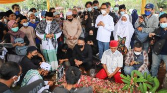 Keluarga dan kerabat berdoa diatas pusara komedian Sapri Pantun di TPU Ulujami, Pesanggrahan, Jakarta Selatan, Selasa (11/5/2021). [Suara.com/Alfian Winanto]