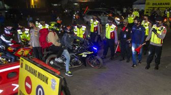 Petugas gabungan menghalau pemudik yang nekat menerobos posko penyekatan mudik di jalur Pantura Patokbeusi, Subang, Jawa Barat, Selasa (11/5/2021) dini hari. ANTARA FOTO/M Ibnu Chazar