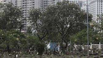 Petugas beristirahat di area makam di Tempat Pemakaman Umum (TPU) Karet Bivak, Jakarta, Rabu (12/5/2021). [Suara.com/Angga Budhiyanto]